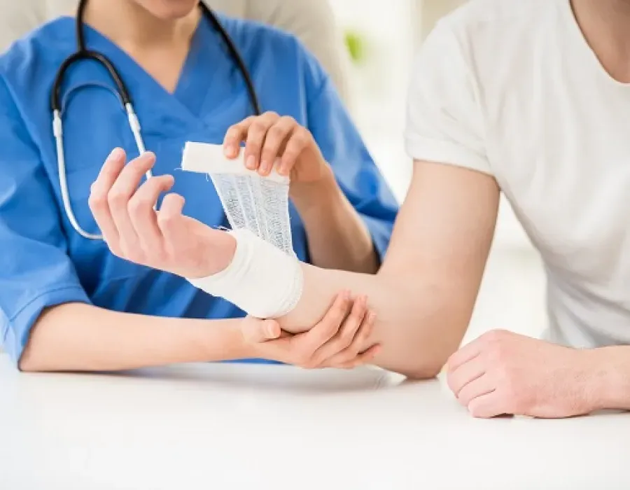 Wound care nurse applying gauze wrap to patient